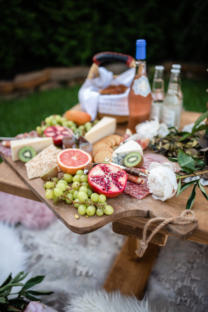 charcuterie board with pomegranate grapefruit and kiwi