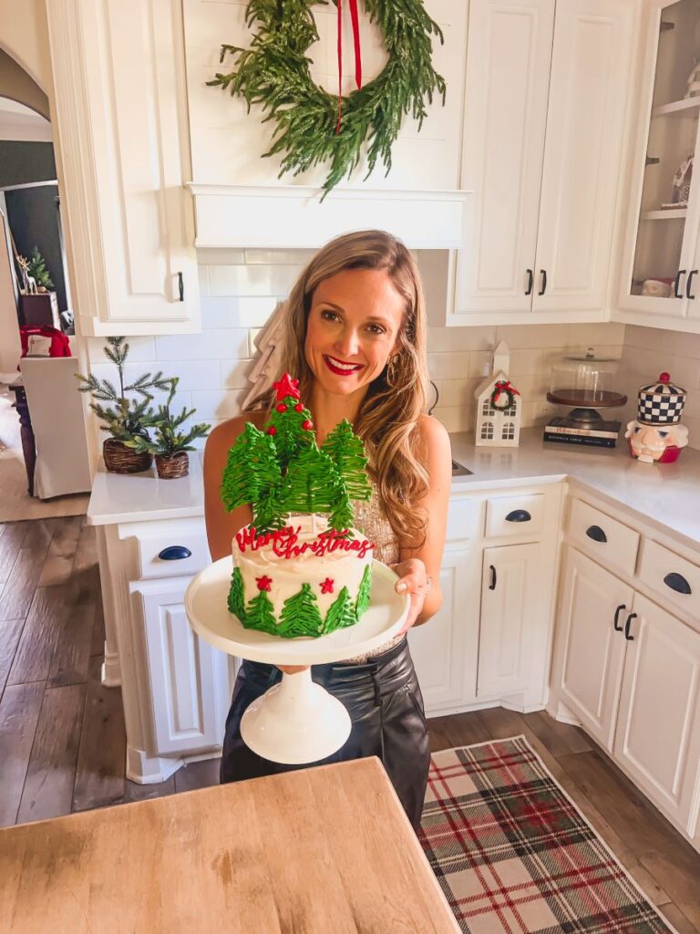 Leanna holding Christmas dessert on a white cake stand