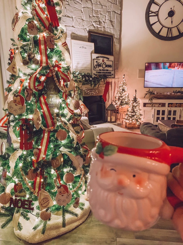 A Santa mug in front of a festive Christmas Tree