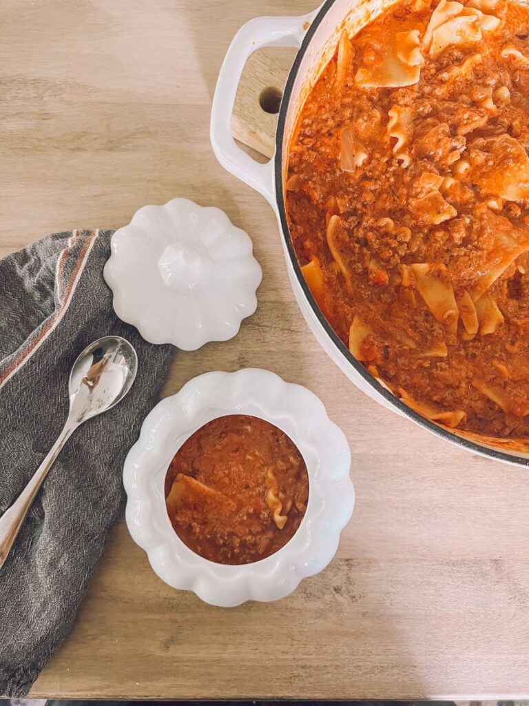 Lasagna soup in a pot pictured next to a cute bowl