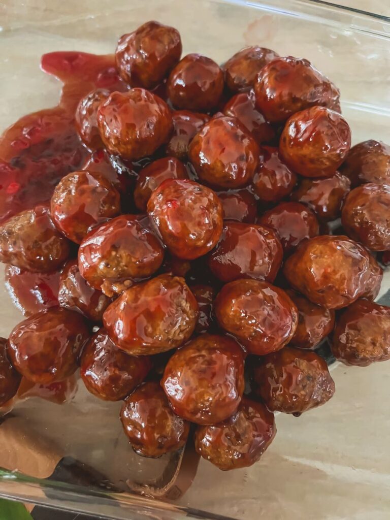 Batch of cooked meatballs with ketchup and grape jelly