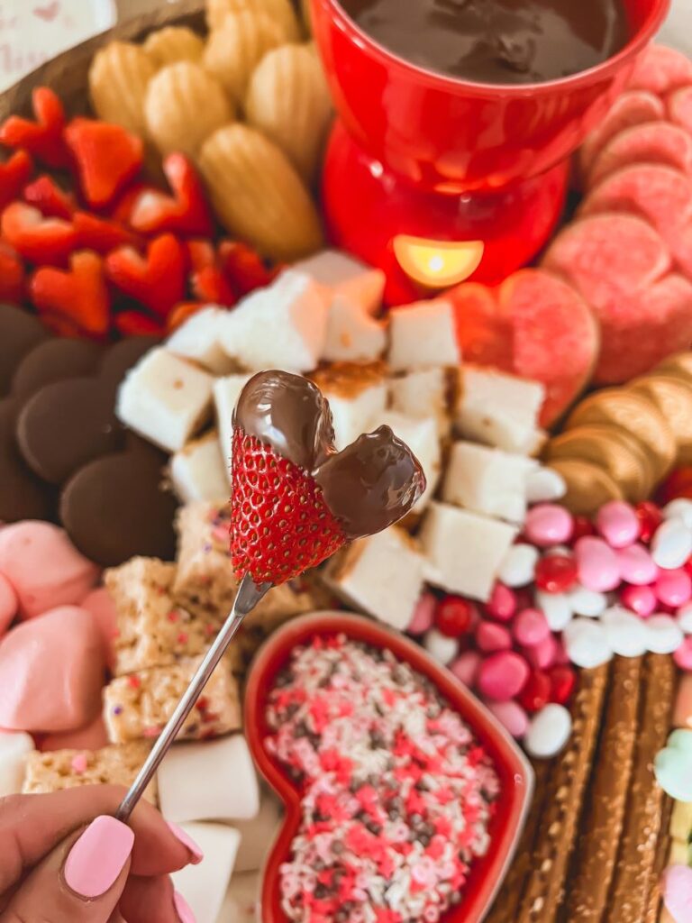 Chocolate-covered strawberry in front of treats on a dessert board