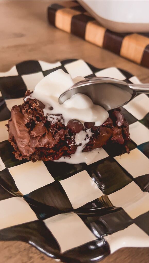 hot cocoa dump cake with whipped cream on a checkered plate