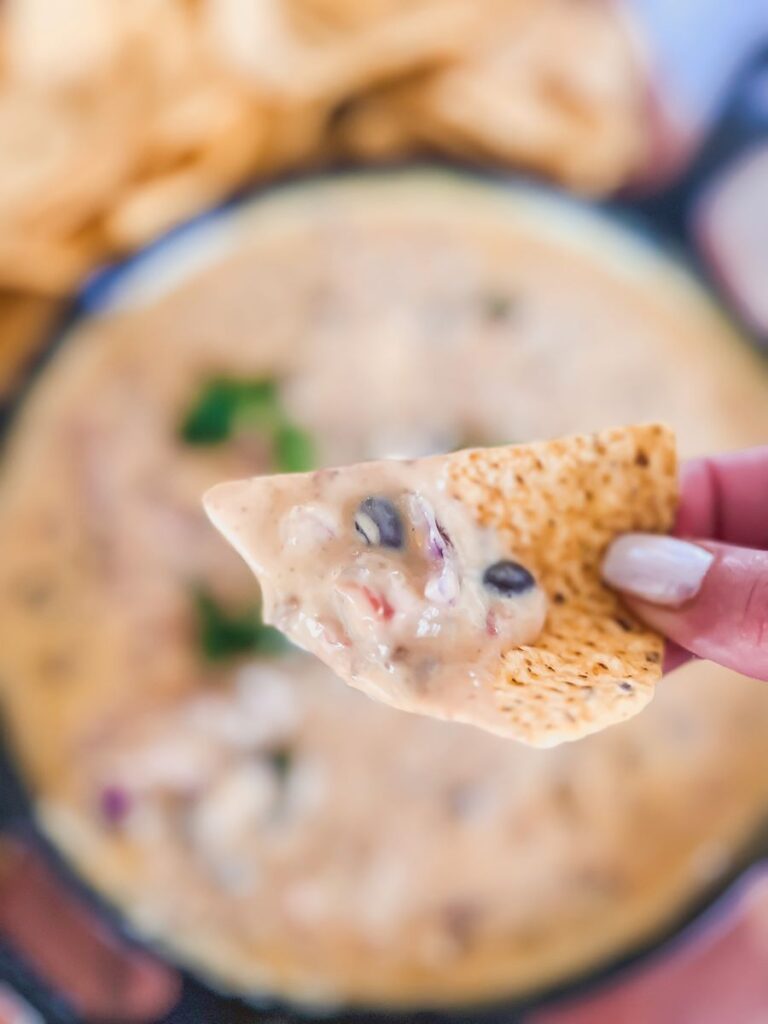 Chip dipped into queso
