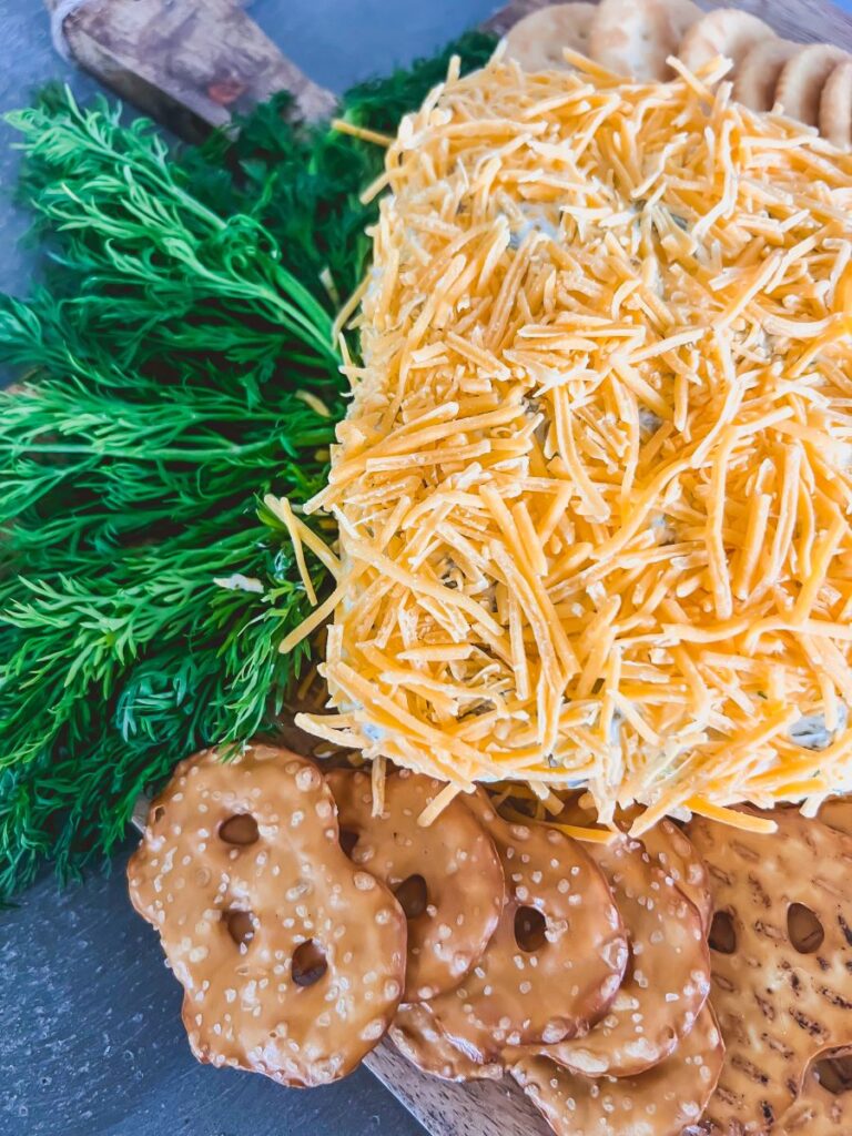 Close-up of Carrot-Shape Cheeseball surrounded by crackers and pretzels