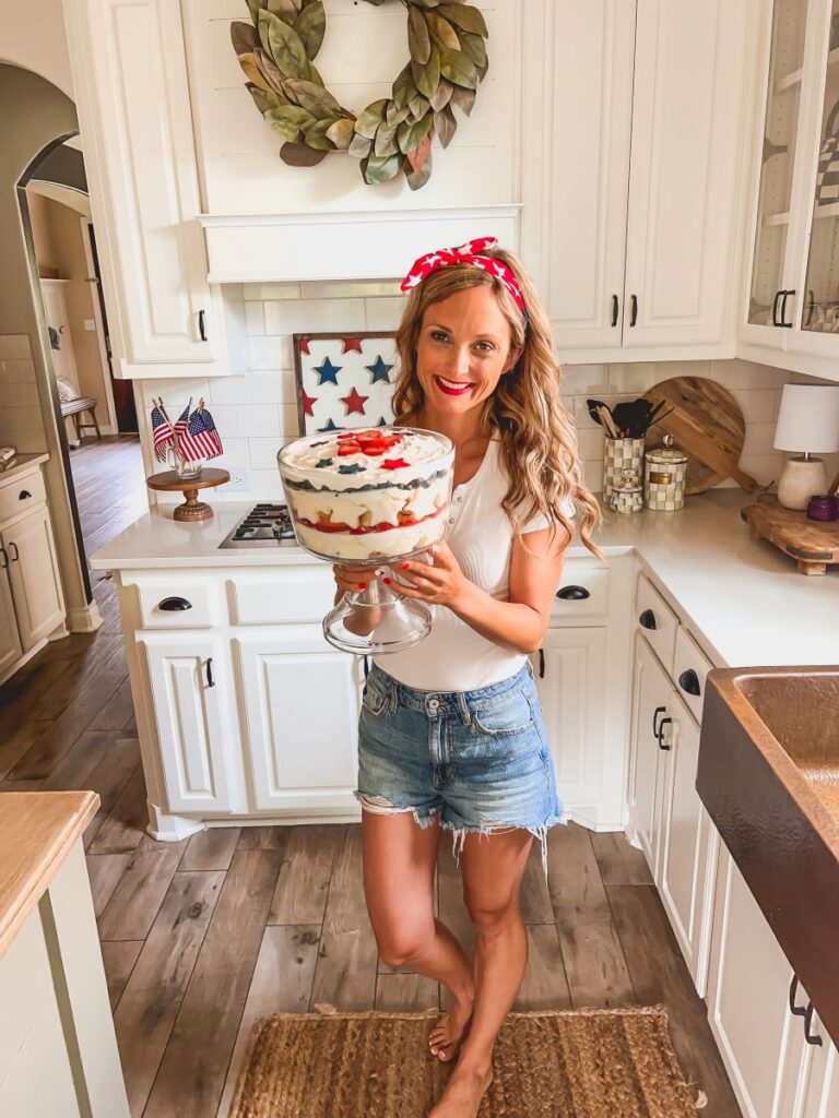 Leanna holding a patriotic berry trifle in a sunny white kitchen