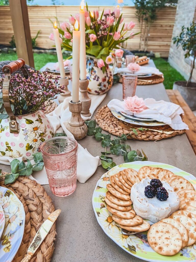 Candles line a table during a pretty garden party