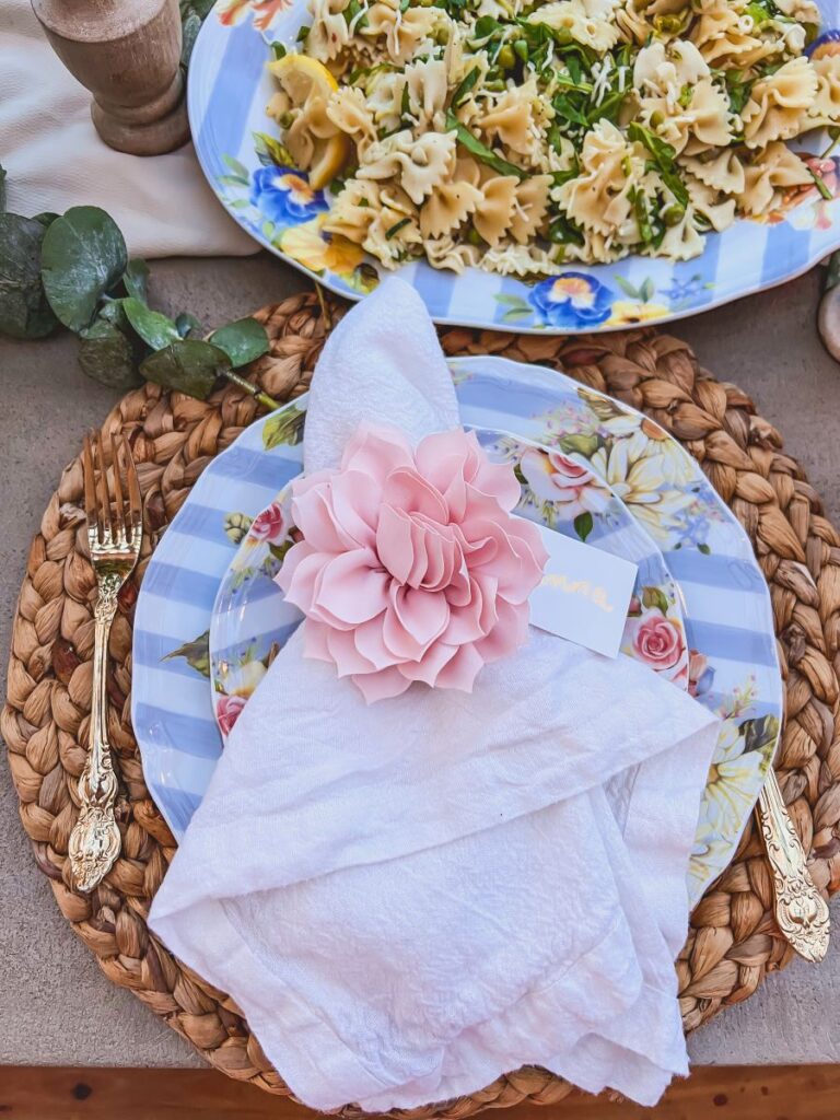White napkin tied with a pink flower and name tag for a garden party