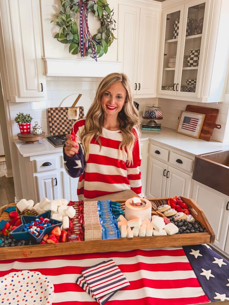 Leanna in a patriotic sweater in front of a festive S'mores Board