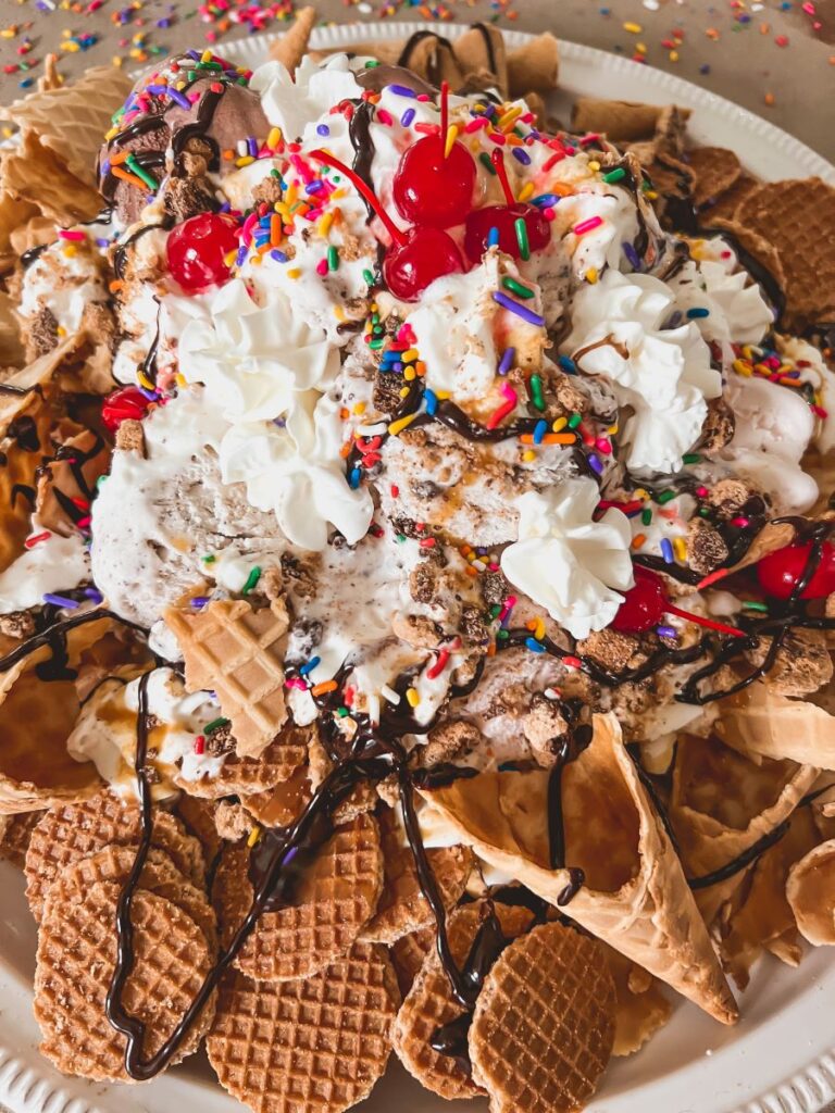 Ice Cream cones on a plate topped with ice cream and toppings