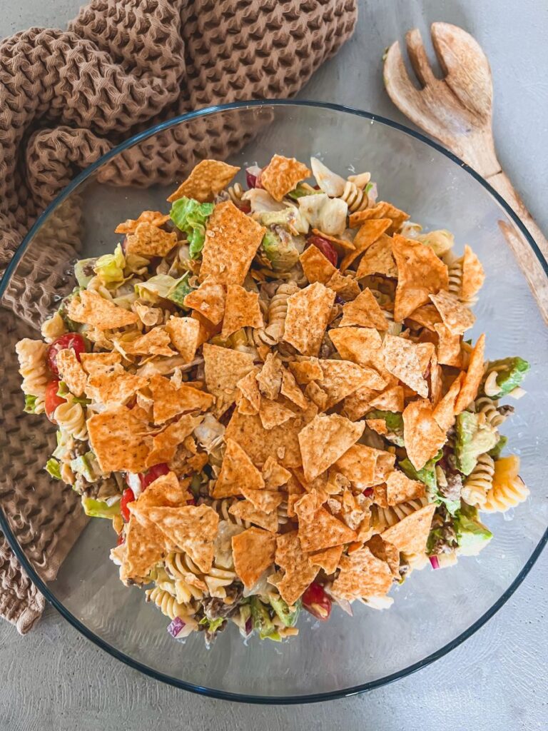 Taco Pasta Salad topped with Doritos in a clear bowl