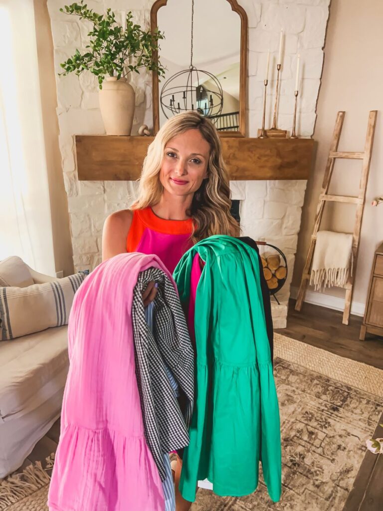 Leanna holding a bundle of cute summer dresses