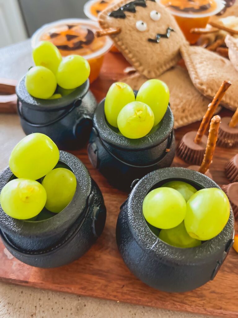 Green grapes in black ini cauldrons