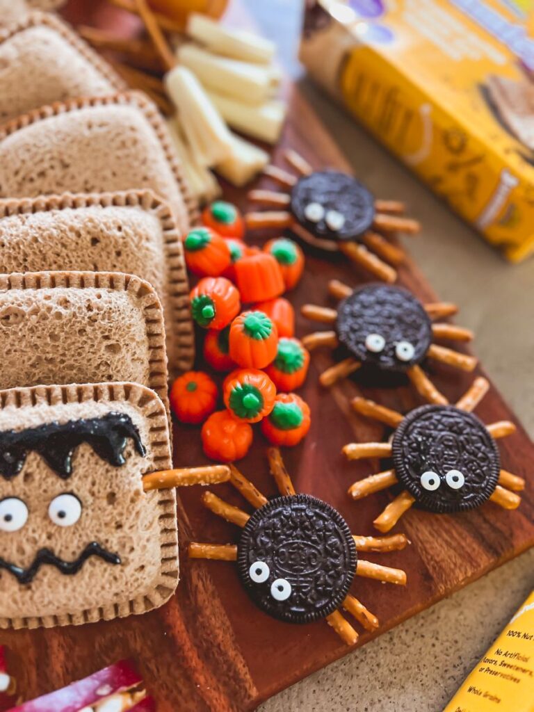 Oreos decorated with pretzel legs for spiders on a Halloween Snack Board