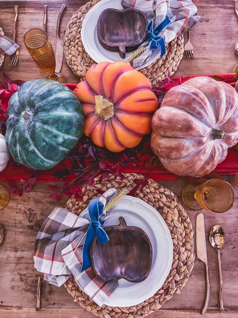 Fall tablescape with pumpkins, plaid napkins, and gold flatware