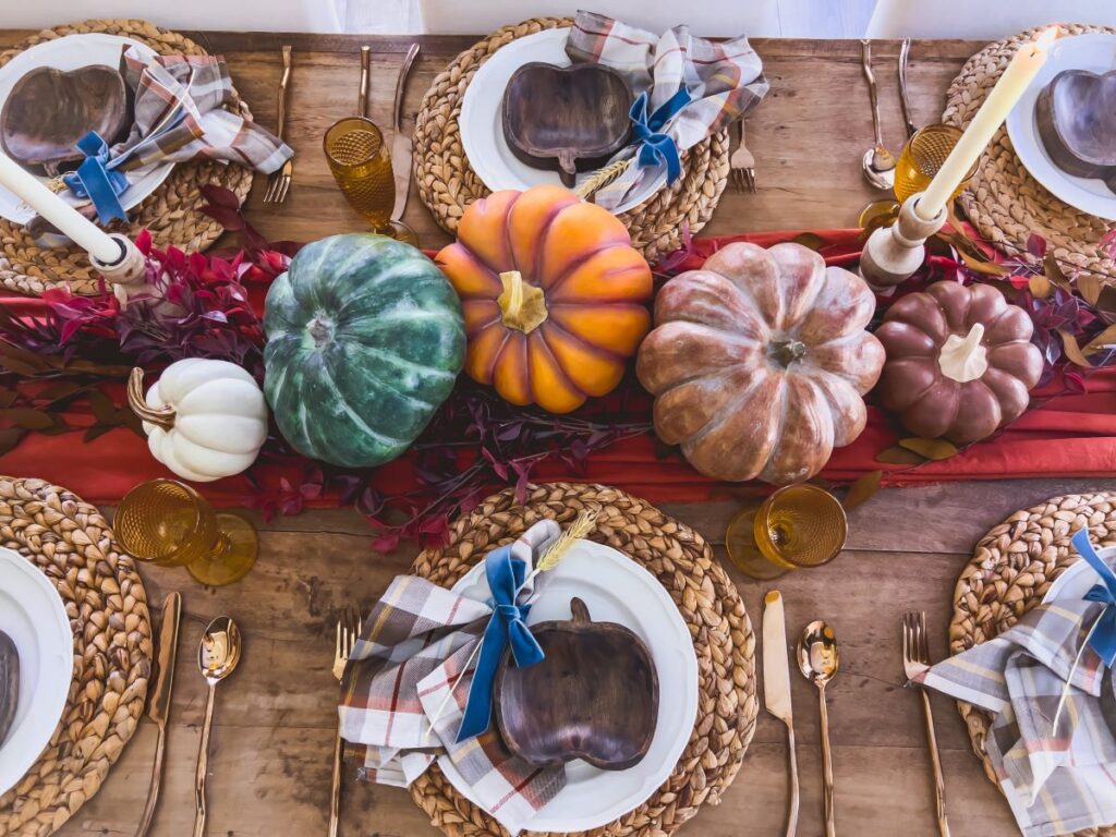 Fall centerpiece with pumpkins and a red table runner