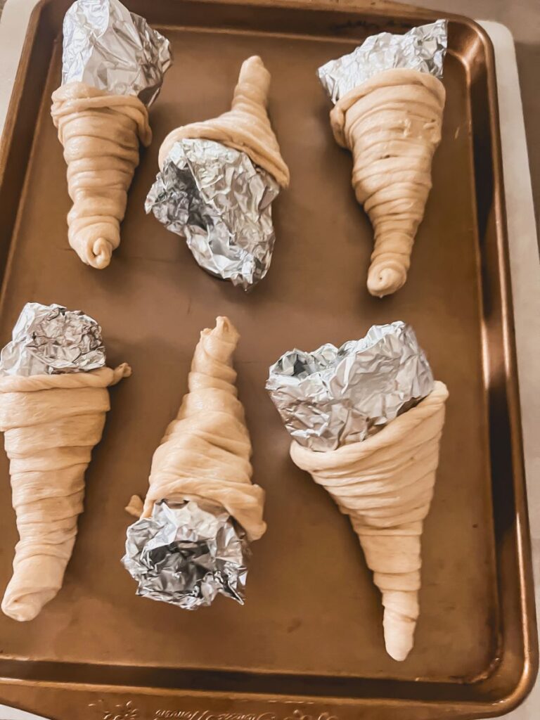 Foil stuffed in cornucopia rolls on a baking sheet