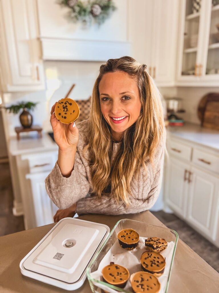 Leanna holding Peanut Butter Oat Cups in a sunny, bright kitchen