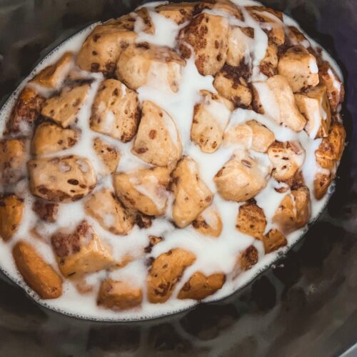 Crockpot Cinnamon Roll Casserole drizzled with icing