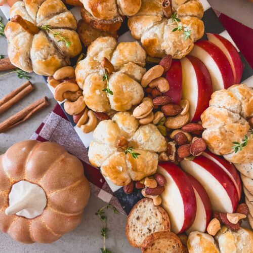Mini Brie Pumpins surrounded by apples on a wooden tray