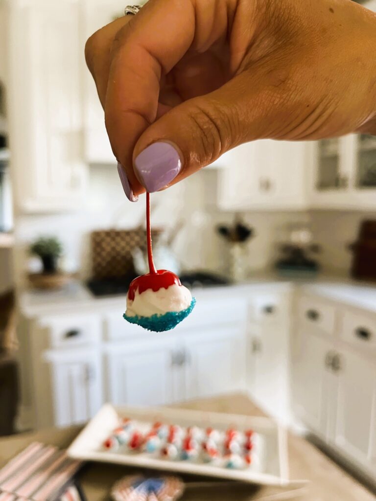 Close-up of cherry dipped in white chocolate and blue sprinkles