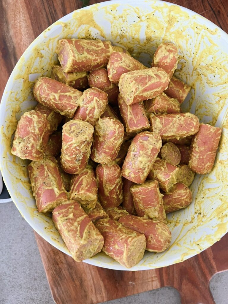 Hot Dog burnt ends covered in sauce in a white bowl