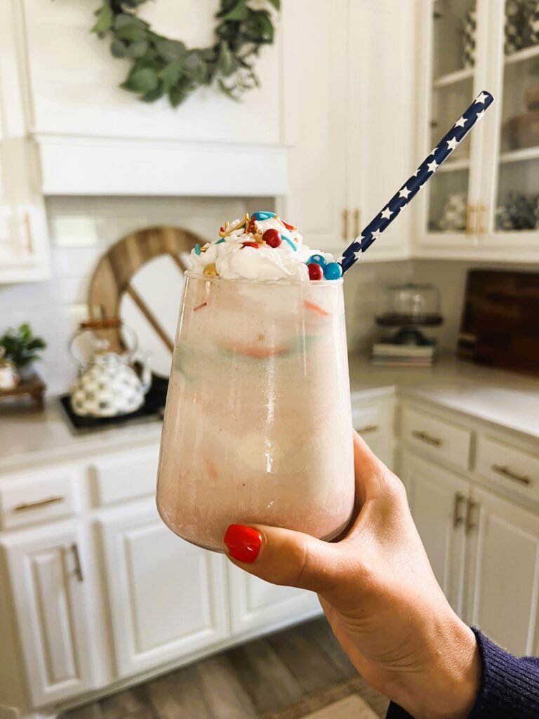 Glass filled with red wine, ice cream, and whipped cream
