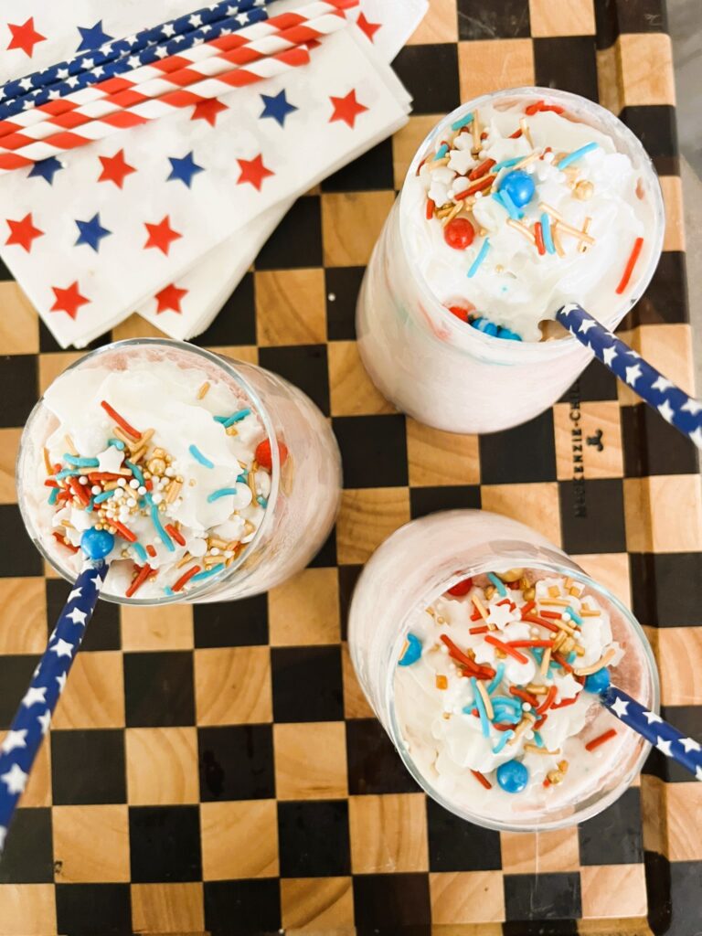 Aerial view of 3 red wine floats garnished with festive sprinkles and straws