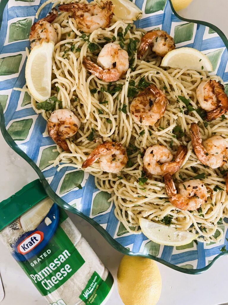 Pasta tossed in lemon sauce and shrimp in a blue and green platter