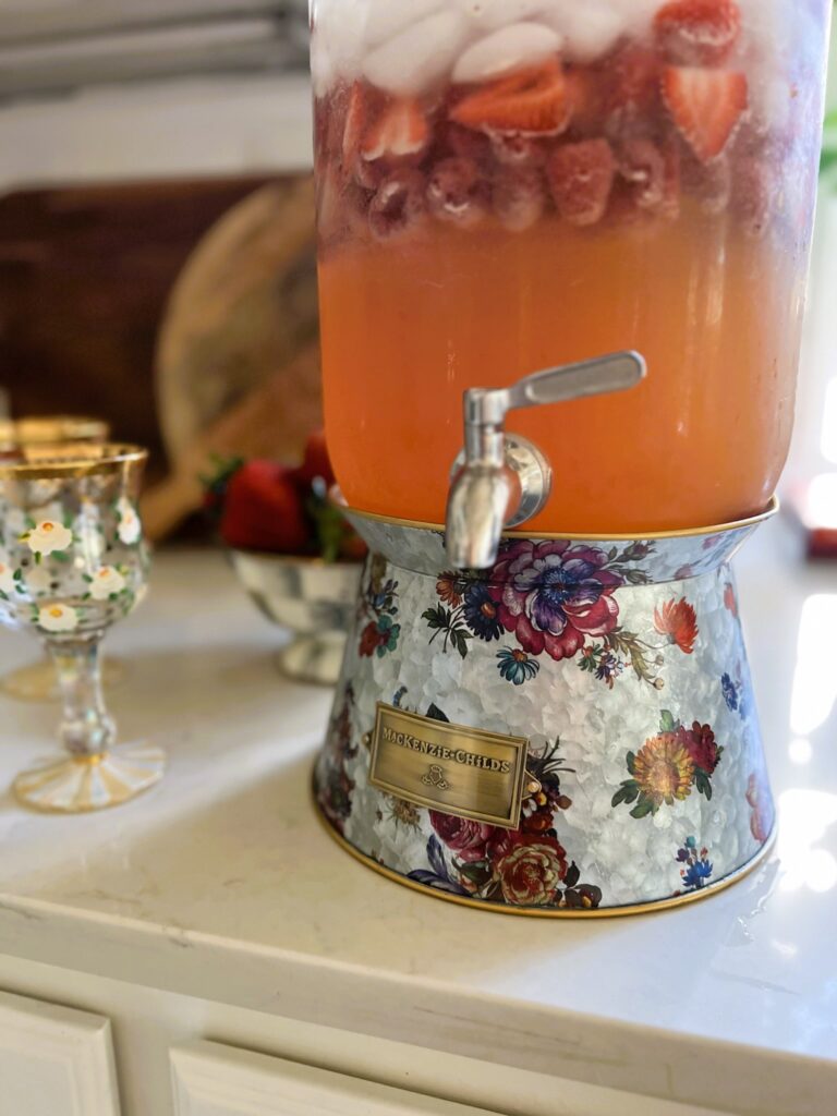 Close-up of floral drink dispenser by MacKenzie Childs filled with Strawberry Lemonade