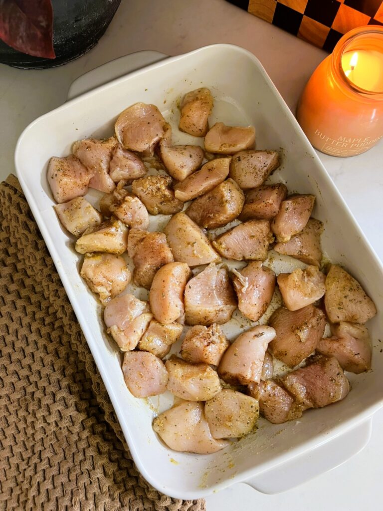 Chicken pieces prepped for baking in a white pan