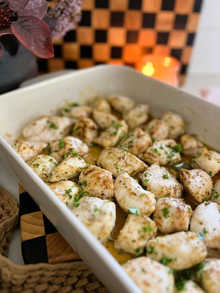 Chicken Bites sprinkled with seasoning in a white pan