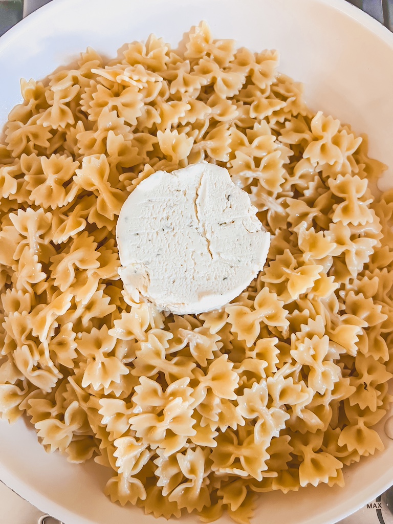 Boursin garlic and herb cheese melting into hot pasta water for a creamy one-pan sauce