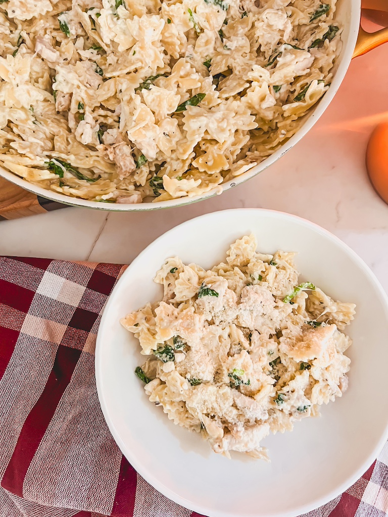Close-up of easy weeknight dinner of creamy Boursin bow tie pasta in a bowl with chicken and Parmesan.