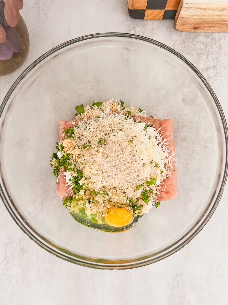 Mixing spinach, feta, and ground beef together in a bowl to make juicy Mediterranean-style burger patties.