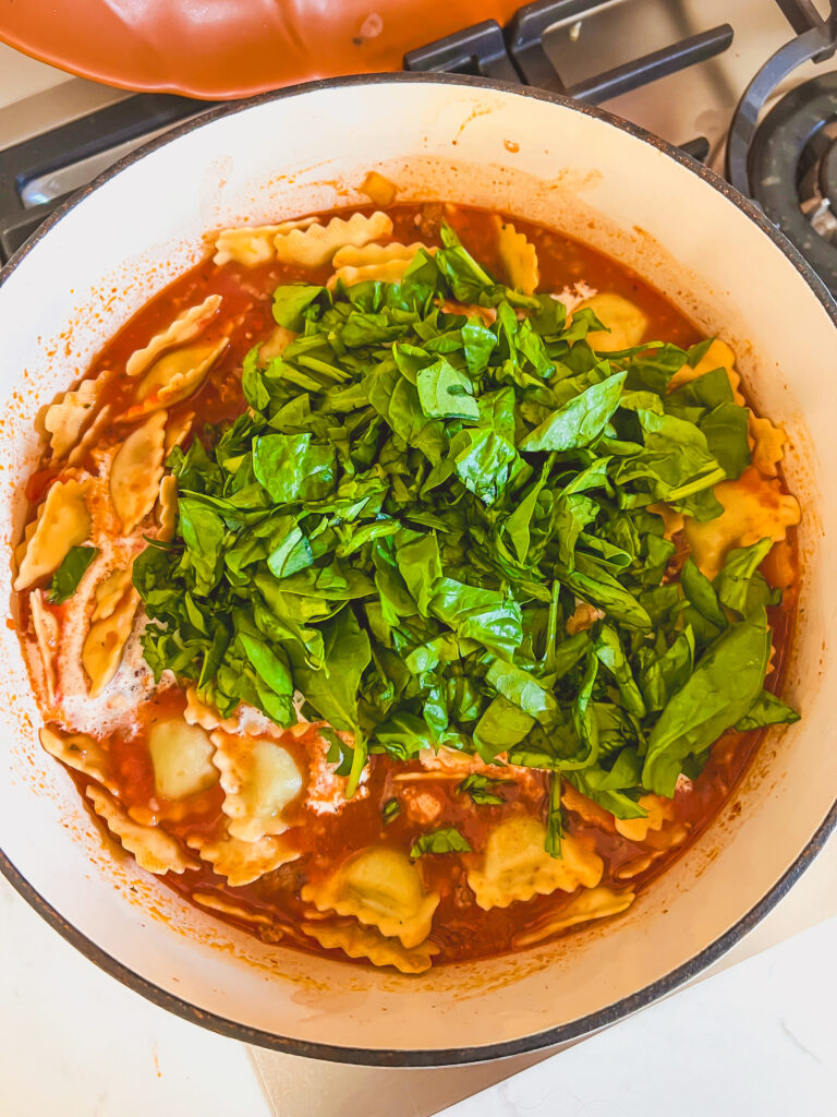 Cheese and spinach ravioli simmering in tomato broth for one pot ravioli soup