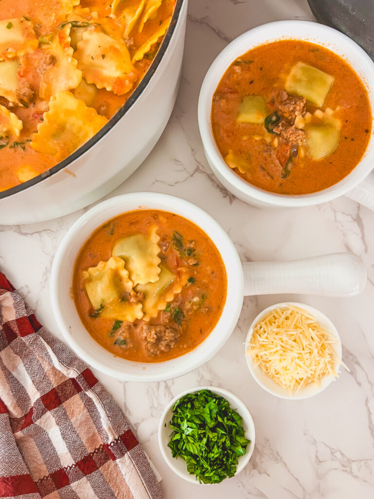 Bowl of creamy one pot ravioli soup with sausage, spinach, and ravioli served for dinner