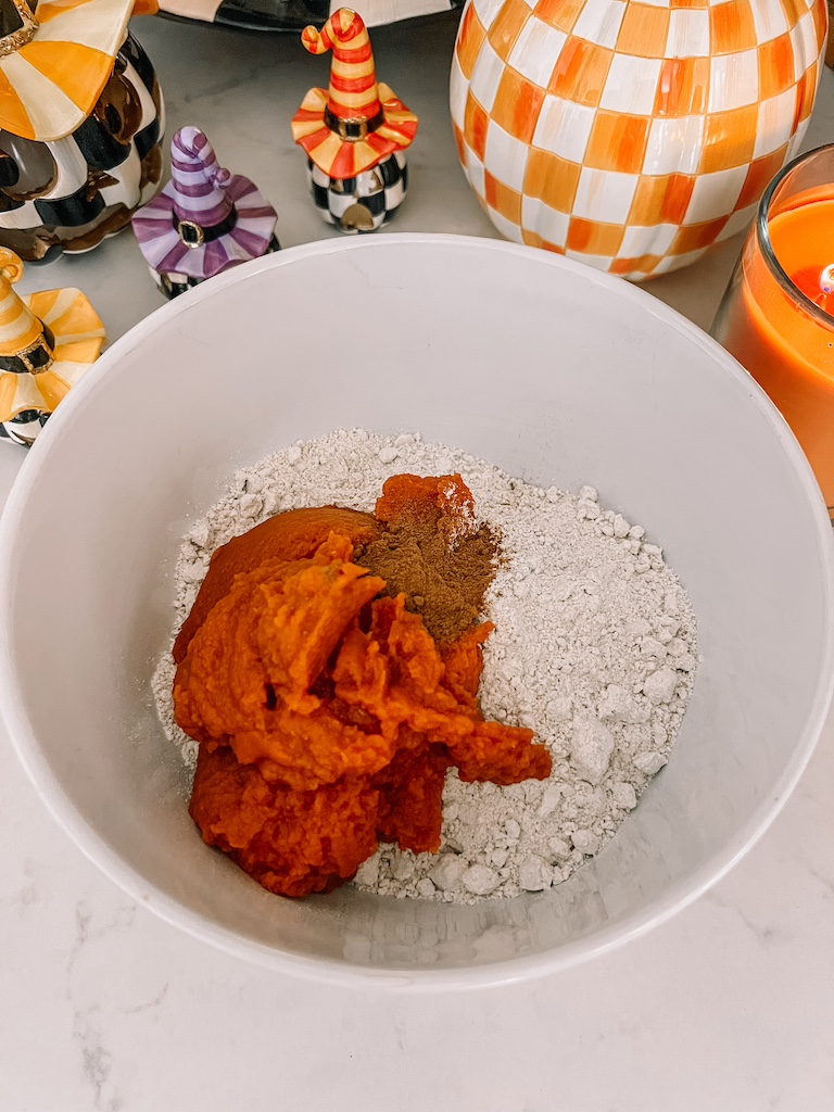 : Mixing pumpkin puree and spice cake mix in a large bowl for easy 3 ingredient pumpkin cookies.