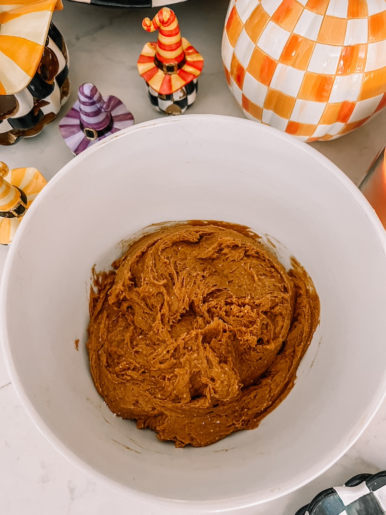 Mixing pumpkin puree and spice cake mix in a large bowl for easy 3 ingredient pumpkin cookies.