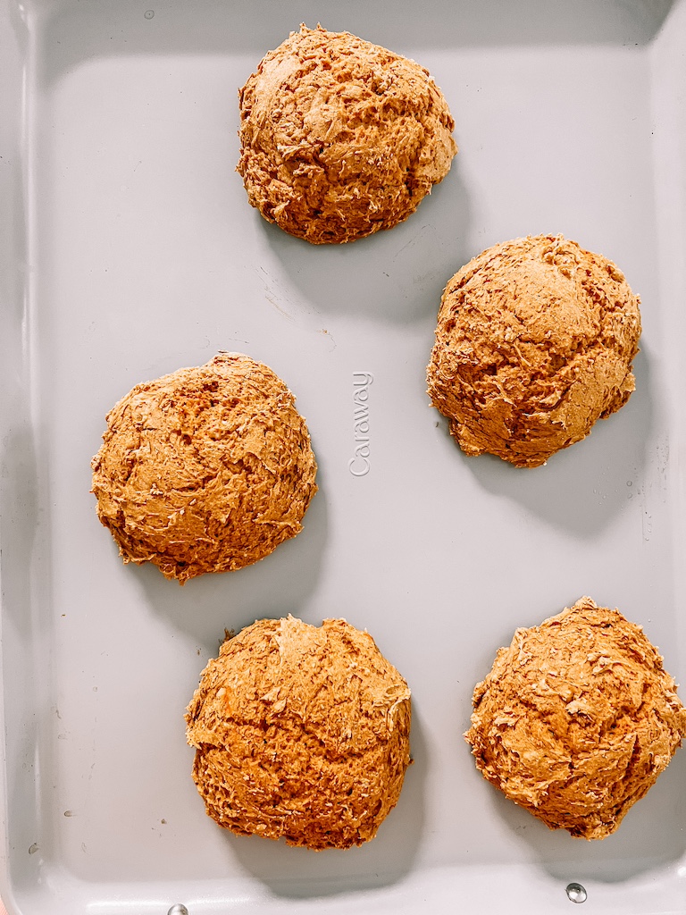 Freshly baked pumpkin cookies cooling on a tray straight from the oven.