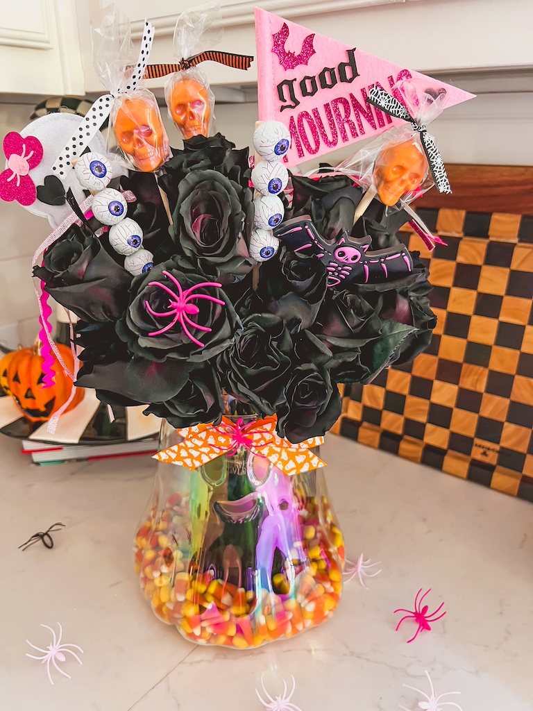 DIY Halloween Boo Basket Floral Arrangement styled as a spooky centerpiece on a decorated Halloween party table.