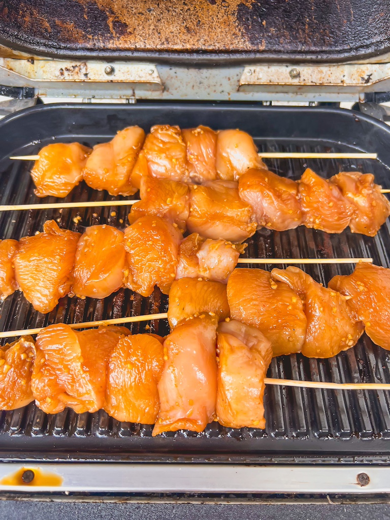 Chicken skewers cooking on an outdoor grill until golden and juicy