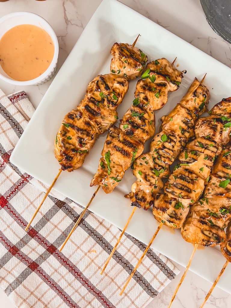 Juicy grilled bang bang chicken skewers drizzled with creamy sauce