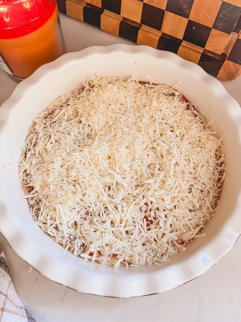 adding the cheese to the pizza dip