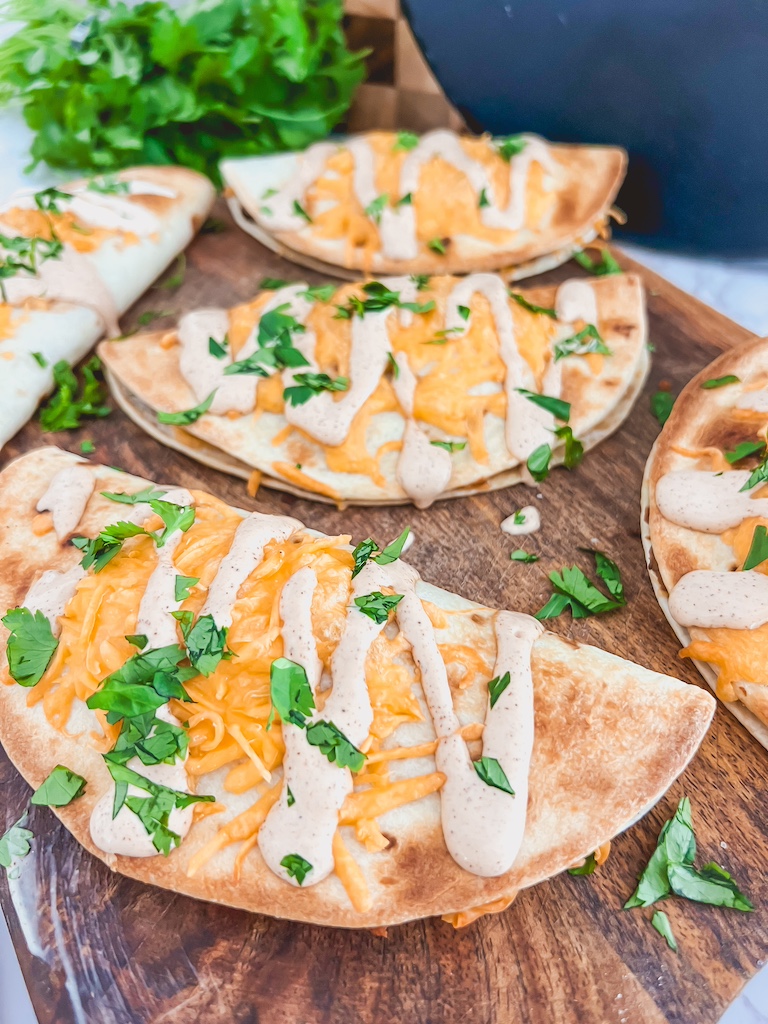 Close-up of baked tacos with melty cheese oozing from crispy tortillas