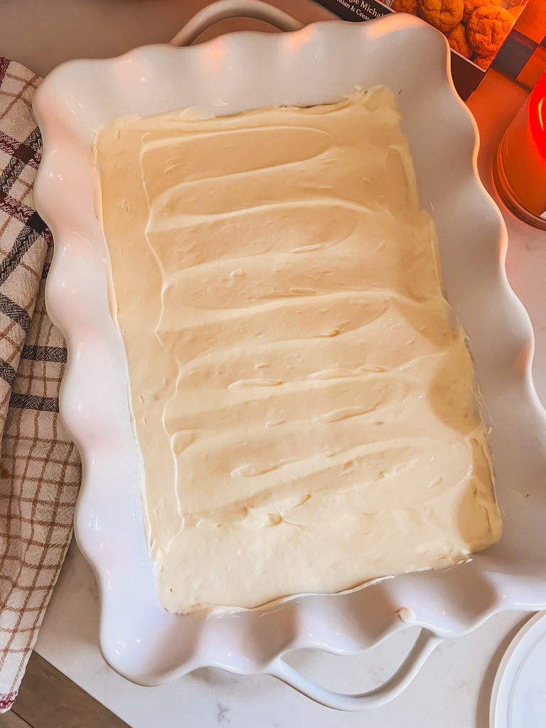 spreading Philadelphia cheesecake filling over crust