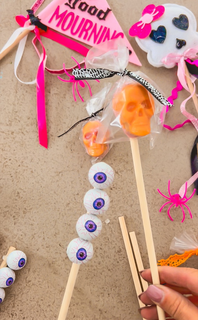 Mini Halloween candies glued onto wooden dowels to create candy flowers for a spooky Boo Basket arrangement.
