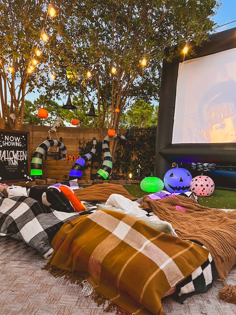 Backyard Halloween movie night decor ideas with blow-up projector screen and spooky-cute details.