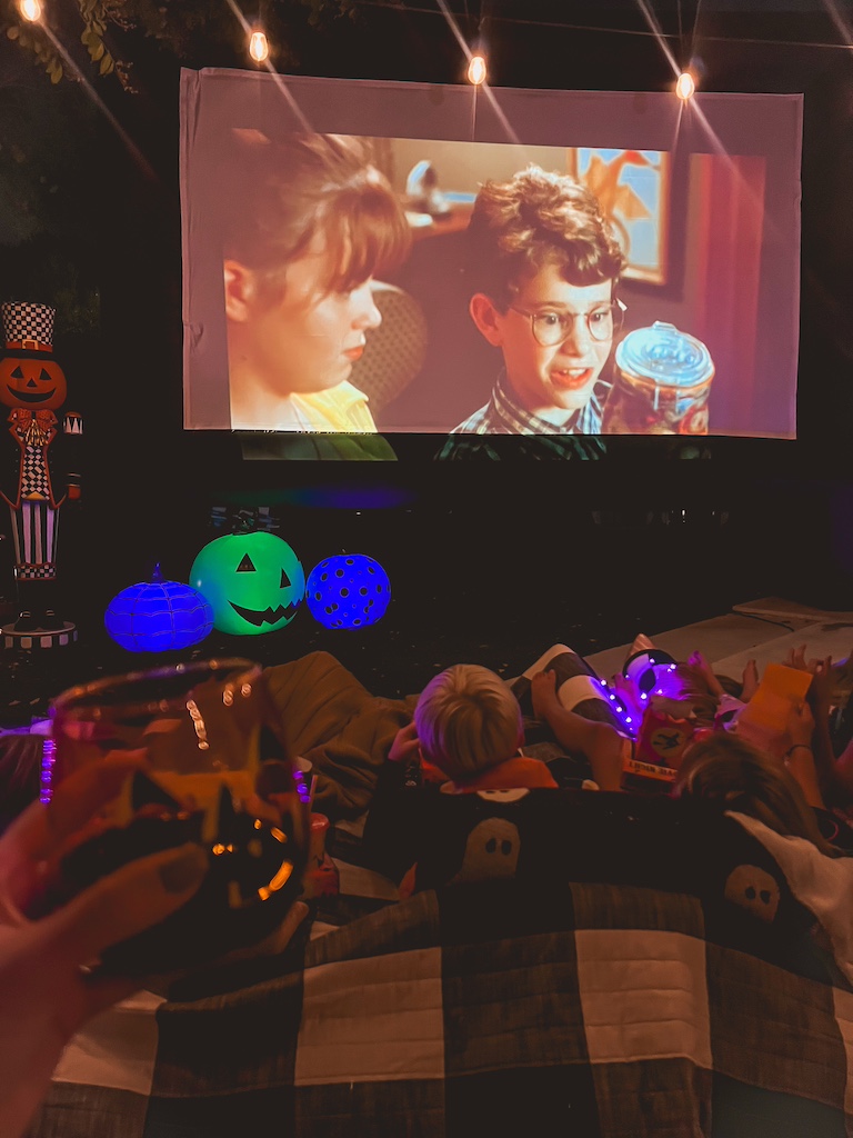 Backyard Halloween movie night decor ideas with blow-up projector screen and spooky-cute details.