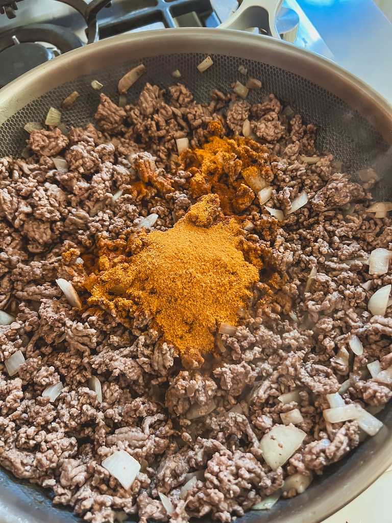 seasoning the taco meat with taco seasoning